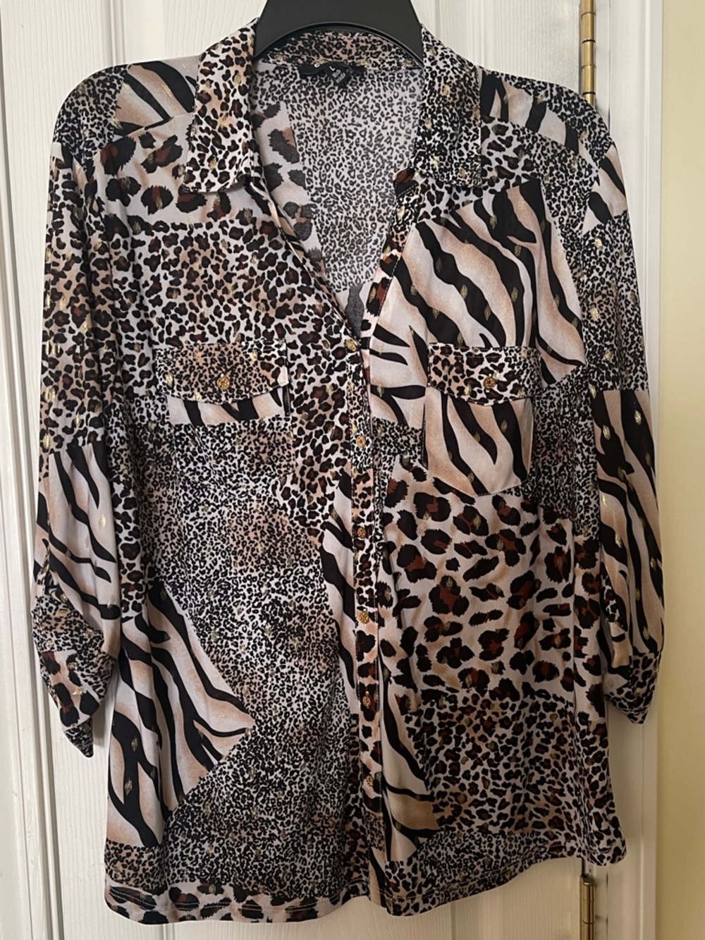 Ladies blouse in multiple African prints and gold tone buttons.